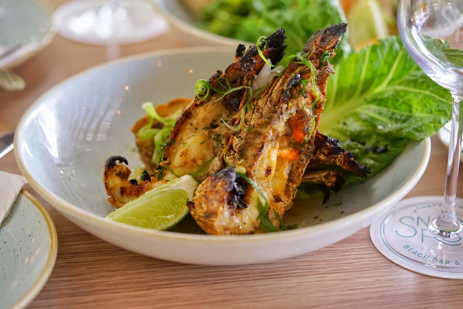 Grilled bugs with lime and greens at Snapper Rocks