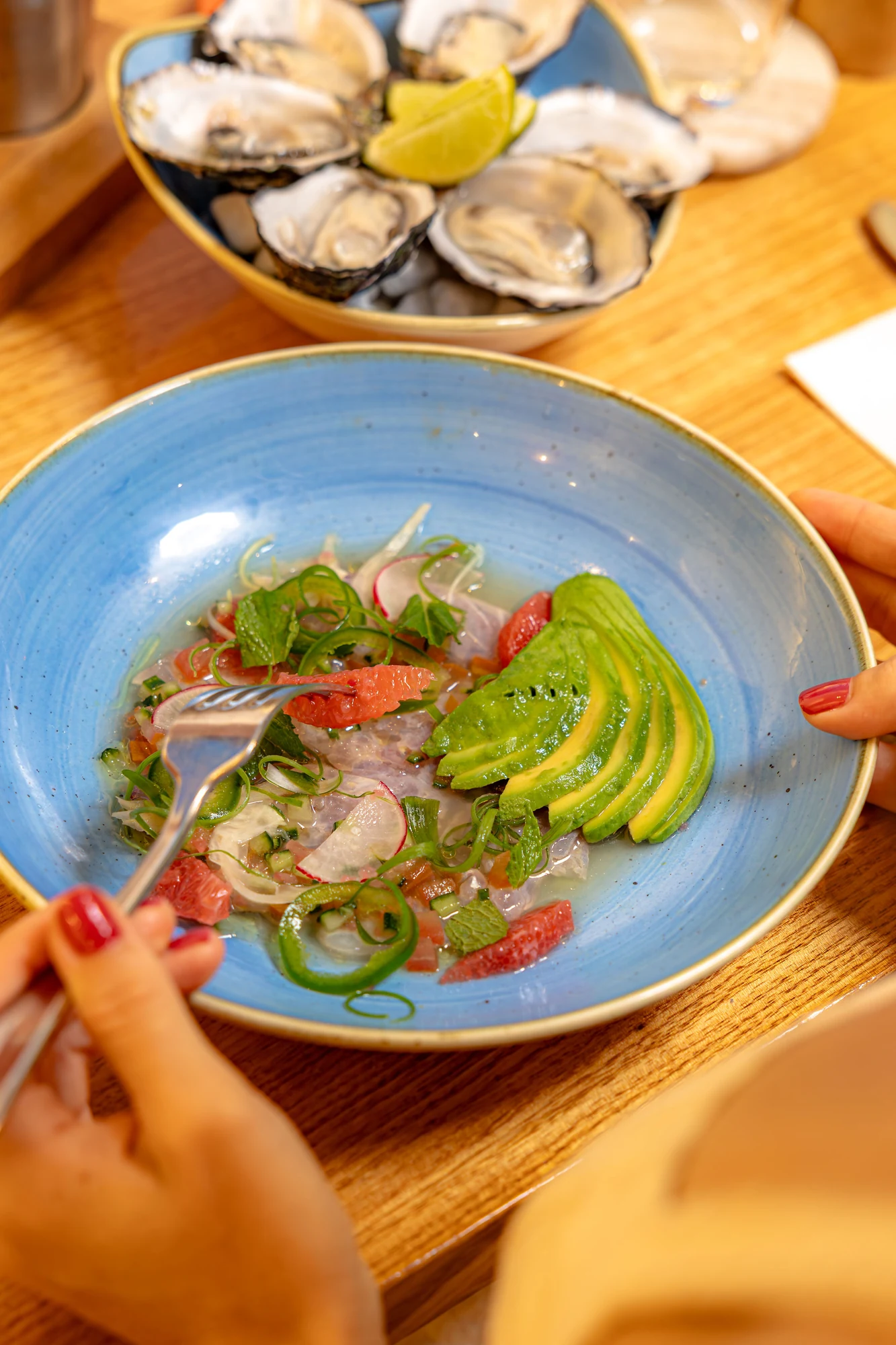 Fresh fish ceviche with avocado, herbs and citrus, with oysters on the table at Snapper Rocks