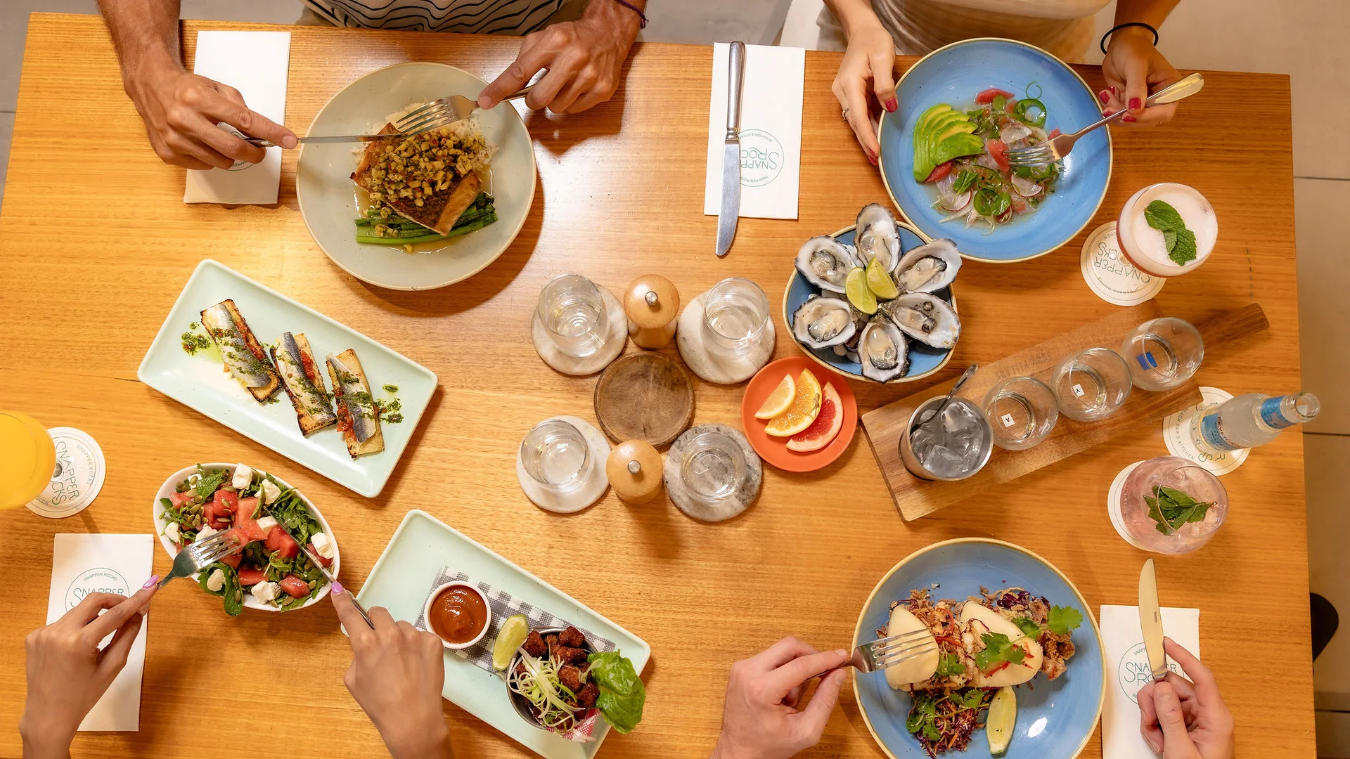 A shared table of seafood, oysters, bao and cocktails at Snapper Rocks